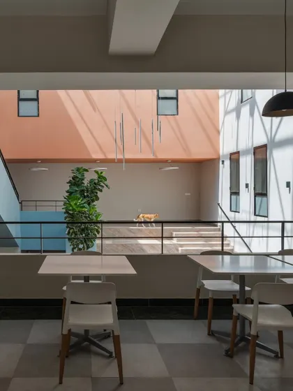 The cafeteria area एट the Nirbhaya Centre, overlooking an open-to-sky courtyard. The design prioritizes natural light and visual connections to green spaces, creating a calm and restorative environment for its users.