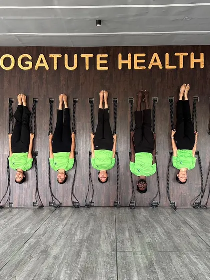 Students practicing inversions on the rope wall, a signature of our Iyengar-inspired approach.