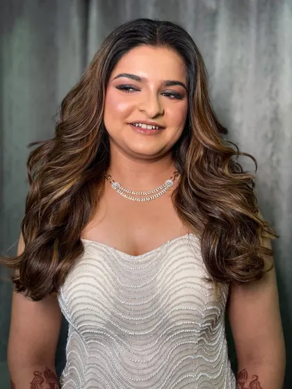 A smiling portrait of the client, looking elegant and happy with her cocktail night glam.