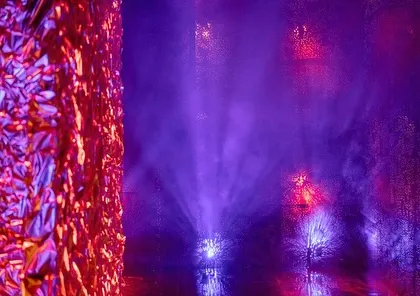 Moody, artistic lighting with red and blue tones on a textured wall, setting the dramatic tone for the 'secret club' Sangeet.