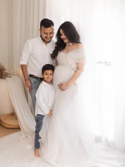 A beautiful family portrait welcoming a new baby. The older brother stands proudly beside his expectant mother, creating a heartwarming image of anticipation and love.