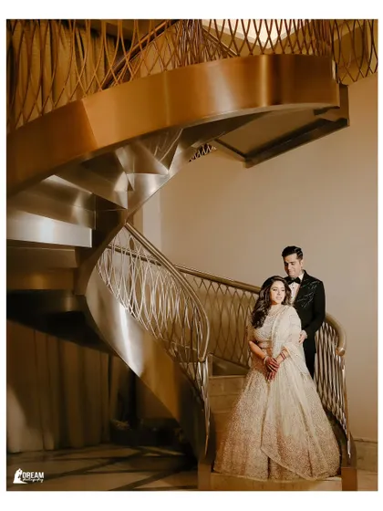 Isht and Paavni posing on a grand spiral staircase in Dubai, a perfect example of a glamorous destination wedding portrait.