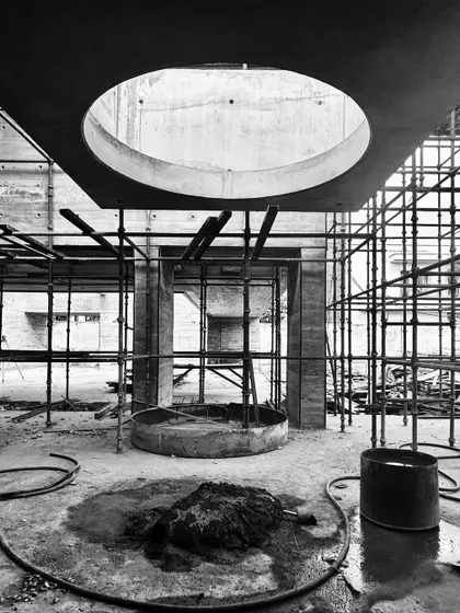 The "Stairwell to Heaven" under construction. This photo shows the base of the circular opening for a future staircase, surrounded by scaffolding and raw concrete.