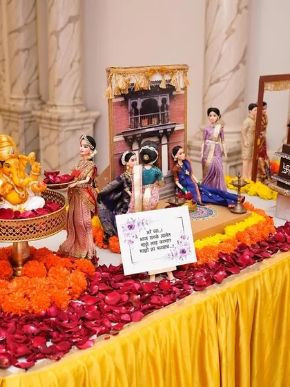 Our baby shower rukhwat setups begin with an auspicious Ganesha idol, surrounded by fresh flowers and dolls ready to welcome the new arrival. The Marathi sign expresses blessings for the mother-to-be.