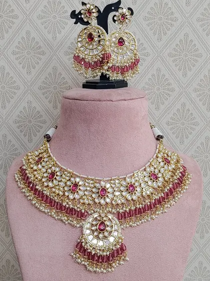 This beautiful Kundan set with pink stones and a mirror work pendant is a lovely choice for a sangeet or mehendi look.