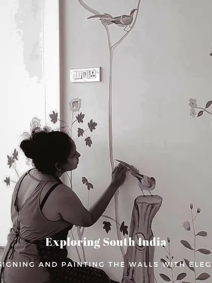 A close-up, edited photo of me painting a bird on the French-themed mural, with text overlay "Exploring South India".