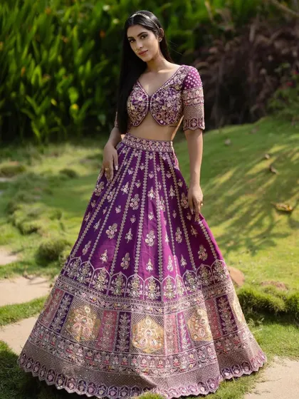 A full shot of this royal purple lehenga. The makeup is kept elegant and understated to balance the richness of the outfit.
