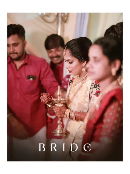 A solemn and beautiful moment as the bride lights the lamp, a significant ritual in many Indian weddings, captured with artistic focus.