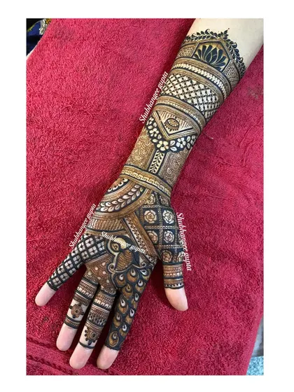 A traditional mehndi design that covers the entire hand and forearm. I used a mix of checks, floral patterns, and a central peacock motif to create a classic and timeless look.
