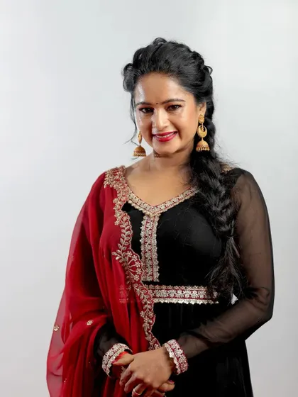 Actress Duniya Rashmi at the Chittara Star Awards. This portrait highlights her beautiful black and red outfit and her warm, engaging smile.