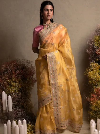 A model draped in a sunshine yellow organza saree with exquisite hand embroidery, inspired by the master craftsman Sabyasachi.