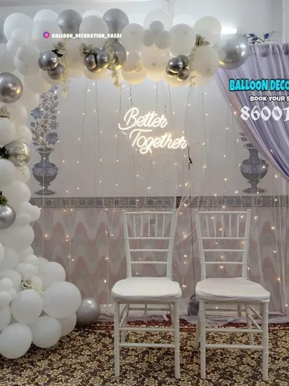 This white and silver balloon arch creates a celebratory and modern feel. Paired with a neon sign and classic Chiavari chairs, it's perfect for a chic engagement party.