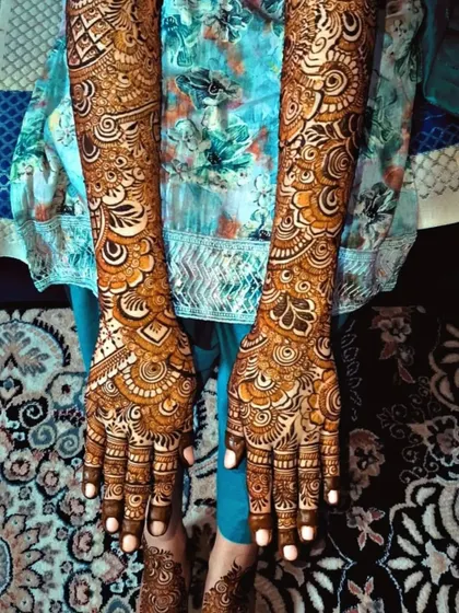 A full view of this stunning bridal henna, showing the design from the fingertips all the way to the elbows. The patterns are dense and detailed, perfect for a traditional bridal look.