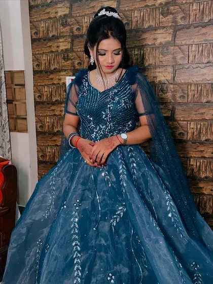 A full-length shot of the bride in a stunning teal gown, ready for her engagement. The makeup is soft and elegant to match.