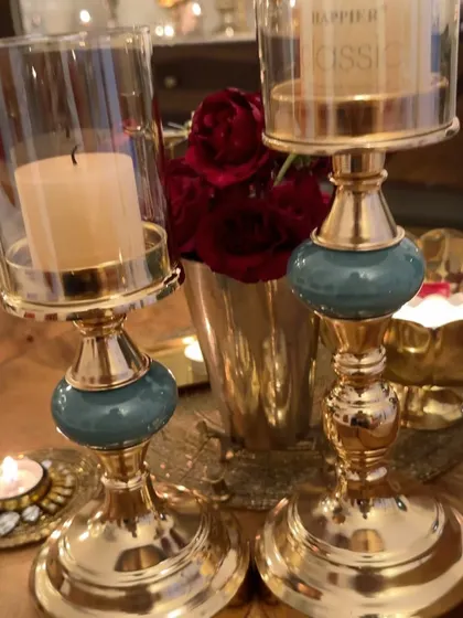 A close-up of the beautiful candle holders. The combination of gold and teal adds a touch of elegance to the festive decor.