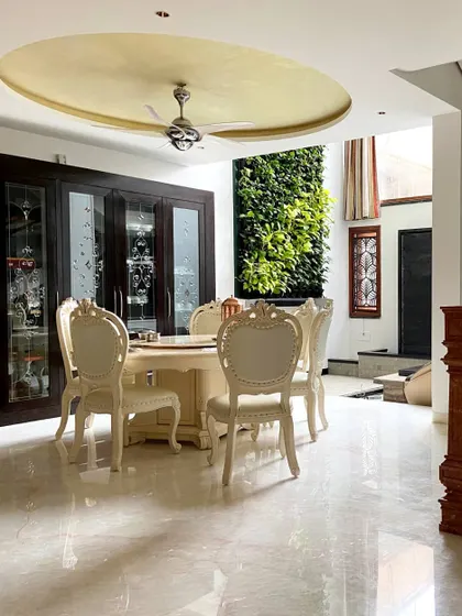 We brought the outdoors in by incorporating a lush vertical garden next to the dining area in this Bengaluru residence. This biophilic design element provides a refreshing natural view, perfectly complementing the elegant, classic furniture and polished marble floors.