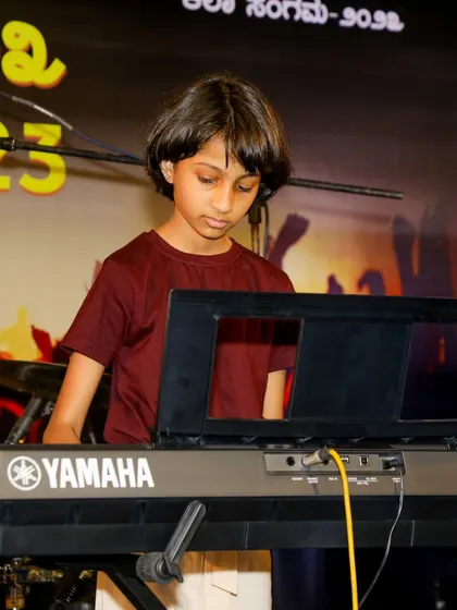 A young keyboardist performing on stage, embodying the creativity and focus that music fosters in children.
