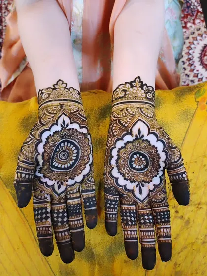 A stunning mandala design on the back of the hands. The symmetry is perfect and the details are beautiful.