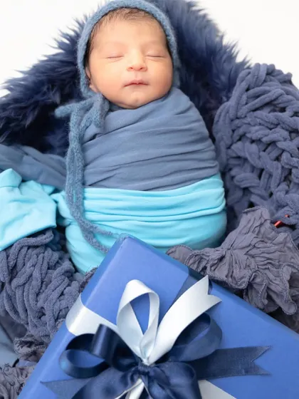 Wrapped in love. A classic swaddled pose with a single prop, like this blue gift box, makes for a perfect and memorable mini session portrait.
