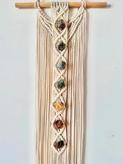 A full view of the 7-chakra macrame wall hanging, showing its long, elegant design.