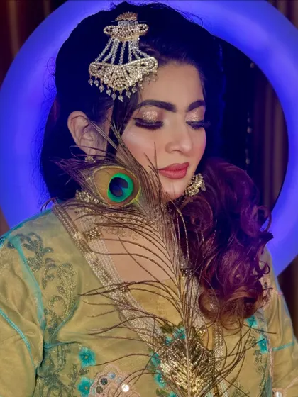 The glittery eye makeup in this shot is absolutely mesmerizing. The peacock feather adds a touch of mystique and artistry to the portrait.