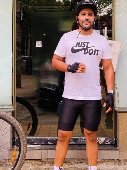 A member in a "Just Do It" shirt, holding a cup of tea. That's our philosophy: work hard, then relax and enjoy.
