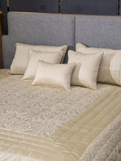 Our beige bed cover set, styled on a modern grey headboard. This view highlights how the soothing beige backdrop and intricate patterns offer both luxury and durability.