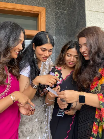 Four friends sharing a laugh as they check out their photo strips.