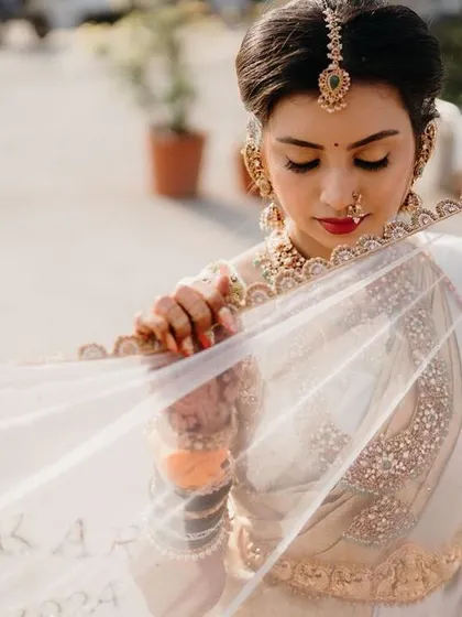 A delicate and artistic shot of the bride. You can see the soft, flawless finish of the makeup and the classic winged liner, which adds a touch of elegance.