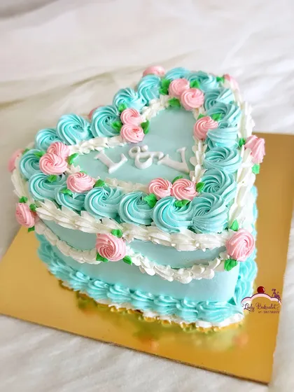 This blue-tiful vintage heart cake has my heart! The intricate buttercream piping and delicate pink roses create a romantic, old-world charm.