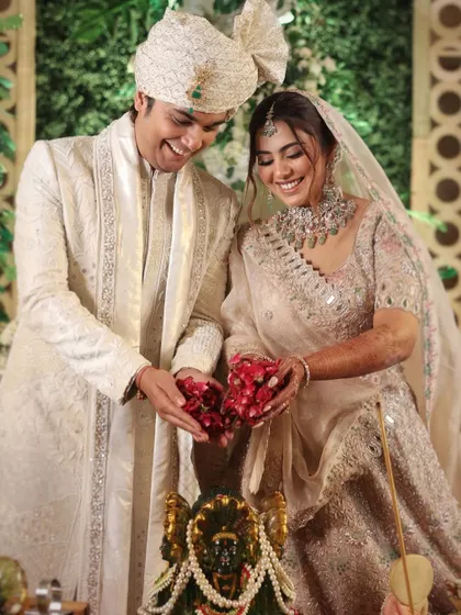The couple offering flowers during their wedding ceremony, a moment of shared prayer and blessing for their new life together.