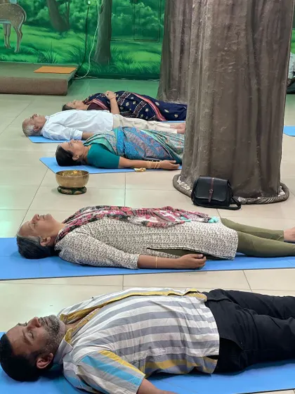 A row of participants in deep relaxation. I often place a small singing bowl near their bodies to enhance the vibrational experience and target specific energy centers.