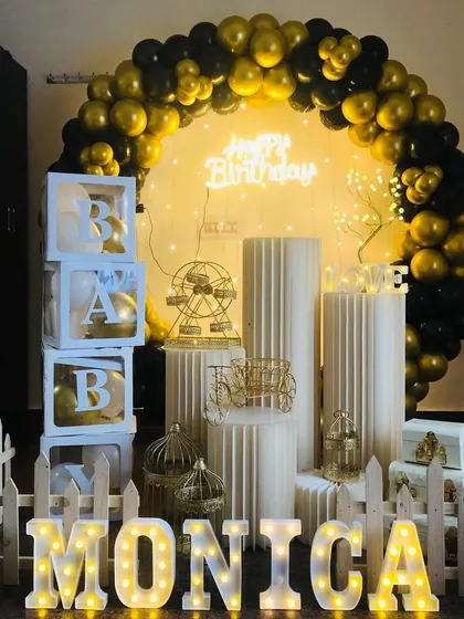 A slightly different angle of the complete black and gold setup, showing the arrangement of the white cylindrical stands and decorative props.