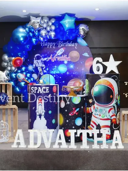 A full view of the space-themed decoration. The setup includes an astronaut cutout, a rocket ship prop, and marquee letters, creating an exciting scene for any aspiring space explorer.