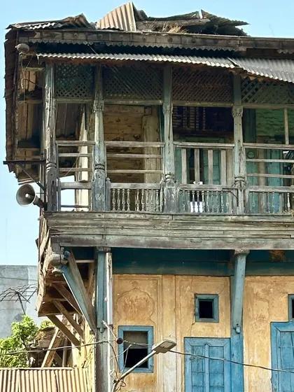 The intricately carved wooden balcony of a Wada in Baroda. These structures demonstrate a sophisticated understanding of material, climate response, and ornamentation in vernacular architecture.