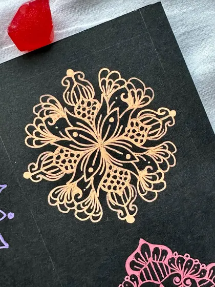 A close-up of a bronze-colored mini mandala from the collection.