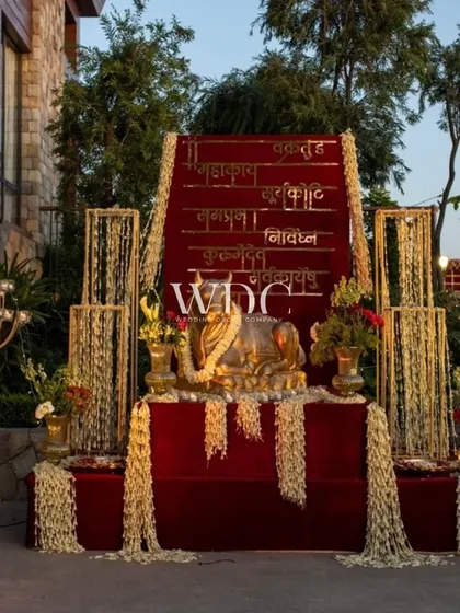 A grand and spiritual installation featuring the sacred Nandi bull, set against a backdrop with the 'Mahamrityunjay' mantra. The setup is adorned with cascading jasmine flowers.