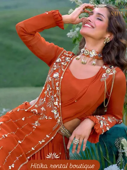 A model looking radiant in a burnt orange Indo-Western draped saree outfit, perfect for a stylish and modern festive look.