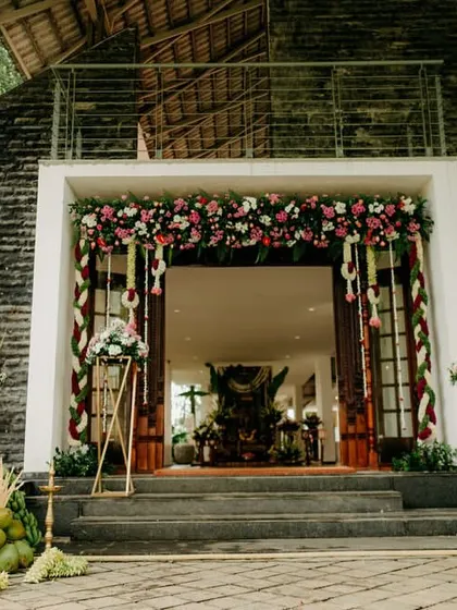 The entrance to a traditional South Indian wedding, decorated with floral garlands and banana saplings, which are symbols of prosperity and welcome.