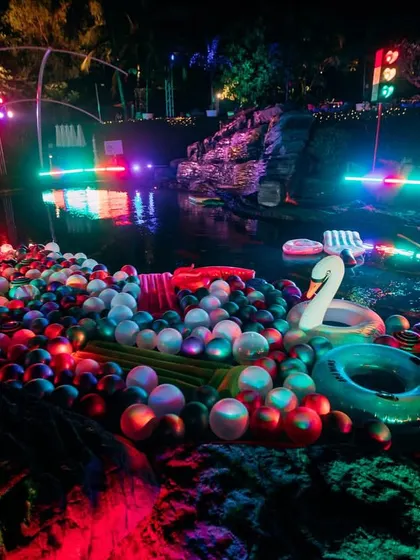 The pool filled with colorful floaters and lit with neon lights, creating a vibrant and exciting atmosphere for the after-party.
