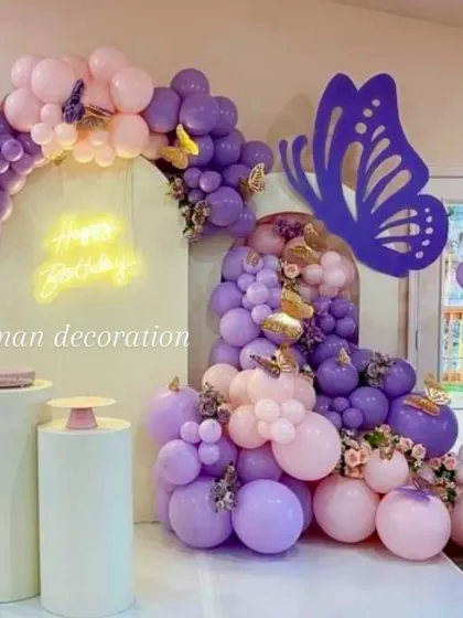 This butterfly-themed party decoration uses a cascade of purple and pink balloons on an arched backdrop. I added large and small butterfly cutouts and a 'Happy Birthday' neon sign.