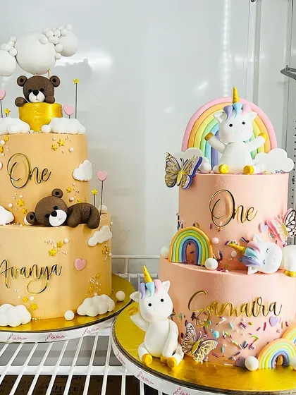 A peek inside my cake fridge. On the left, a two-tiered teddy bear cake, and on the right, a two-tiered unicorn cake, both ready for a first birthday celebration.