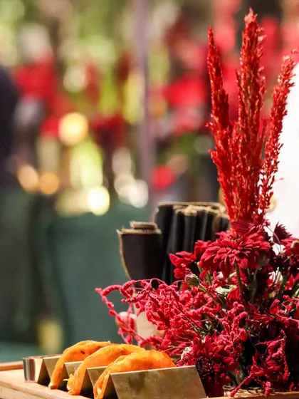 A close-up of our mini tacos, nestled in a tray and accented with vibrant red floral decor. We believe the entire presentation, including the environment, contributes to the dining experience.