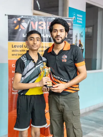 A proud coach moment, presenting a trophy to a young winner. Seeing their hard work pay off is the most rewarding part of my job.