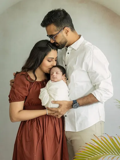 Two hearts became three. A quiet, tender moment as new parents embrace their baby, a memory of the beginning of their greatest adventure together.