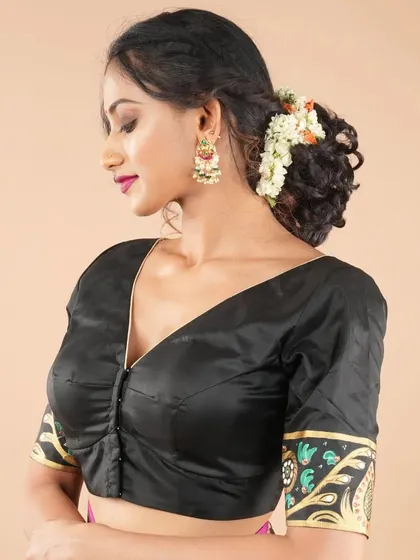 This black blouse features Kalamkari art on the sleeve cuffs, offering a subtle yet artistic touch. The V-neck and front button closure make it a classic and comfortable fit.