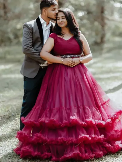 An intimate couple's portrait in a forest setting. The tiered magenta gown adds a touch of romance and elegance.