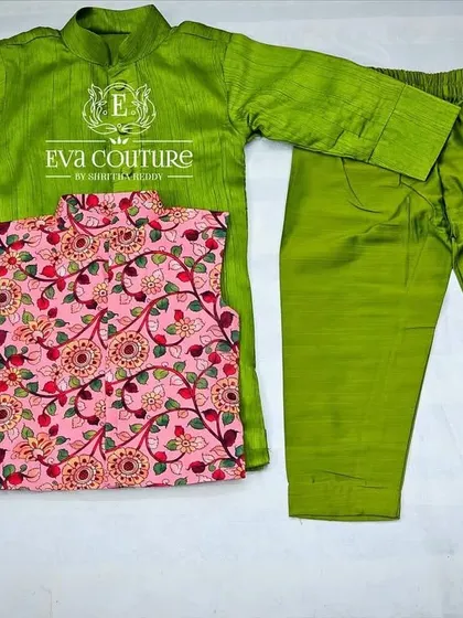 A modern three-piece kurta set for boys. It includes a lime green raw silk kurta and pajama, paired with a contrasting pink printed Nehru jacket.