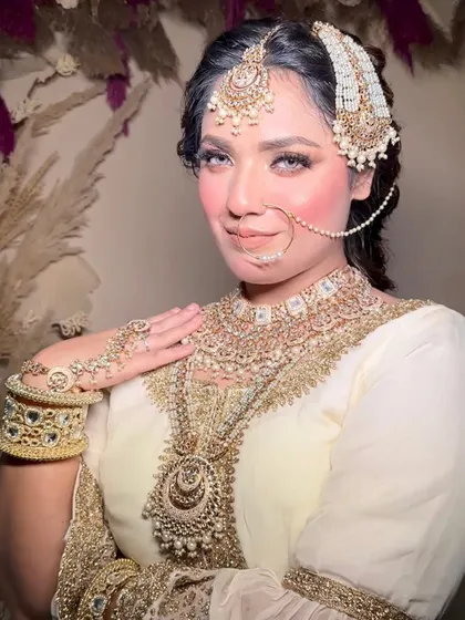 A confident and regal bridal portrait. The makeup enhances her features with a defined contour and striking eyes, fit for a queen.