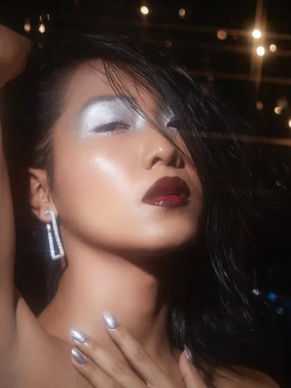 A glamorous look from a student's second portfolio shoot, featuring a silver metallic eye and a glossy dark lip under dramatic lighting.